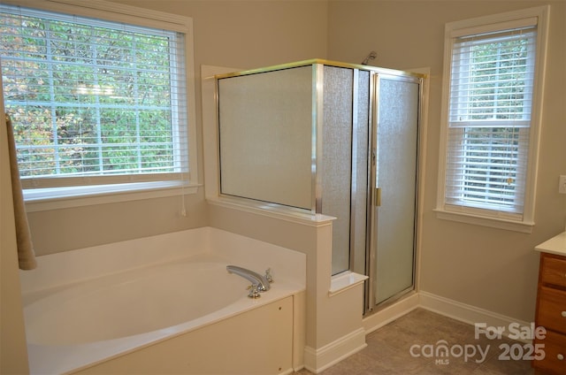 bathroom featuring tile patterned flooring, vanity, a healthy amount of sunlight, and shower with separate bathtub