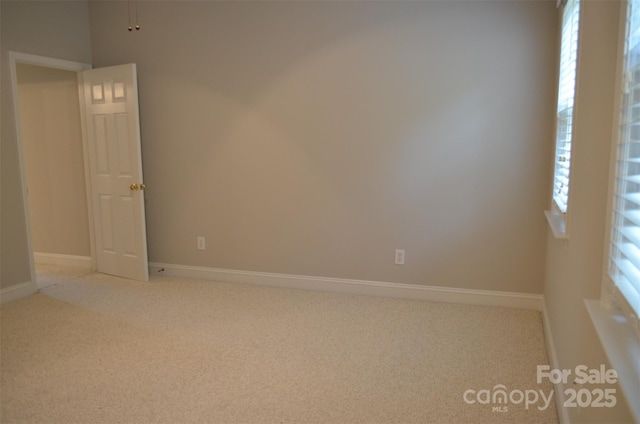 unfurnished room featuring light carpet and plenty of natural light