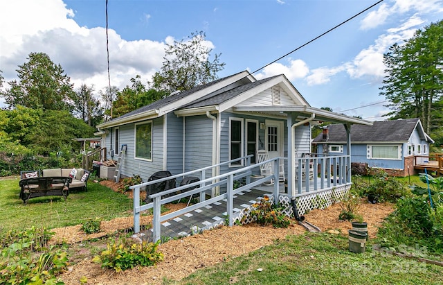 bungalow-style house with an outdoor hangout area, a wooden deck, and a front lawn