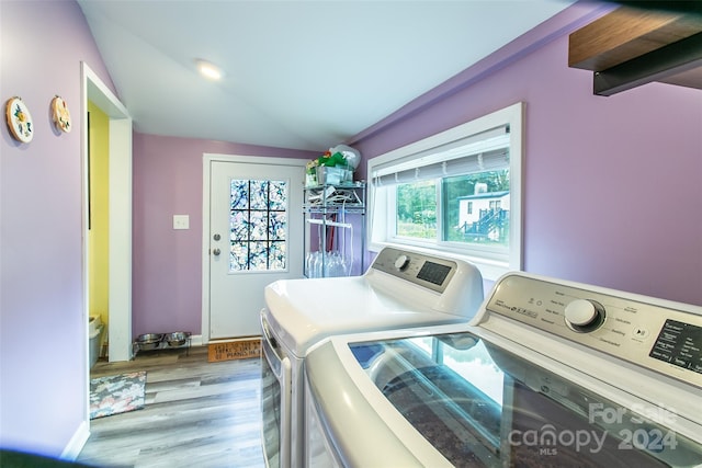 washroom featuring light wood-type flooring, washer and dryer, and plenty of natural light