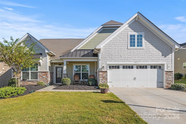 craftsman house with a front lawn and a garage