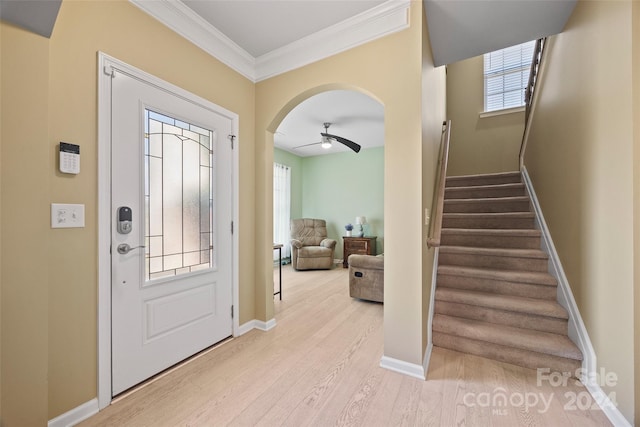 foyer with light hardwood / wood-style floors, crown molding, and ceiling fan