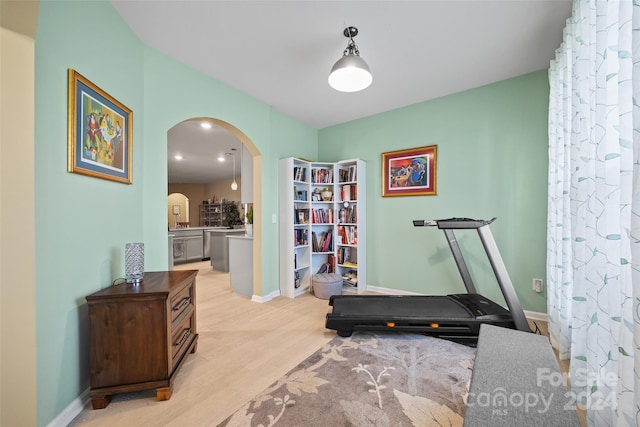 exercise room with light hardwood / wood-style flooring