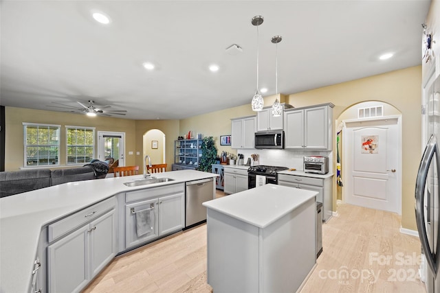 kitchen featuring light hardwood / wood-style flooring, appliances with stainless steel finishes, sink, and a kitchen island