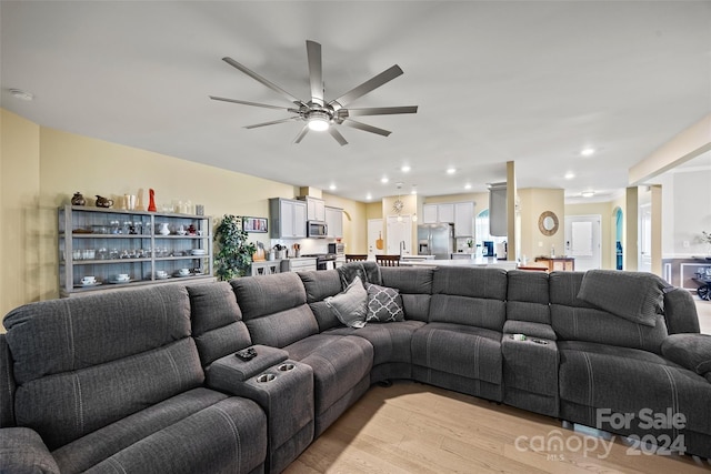 living room featuring ceiling fan and light wood-type flooring