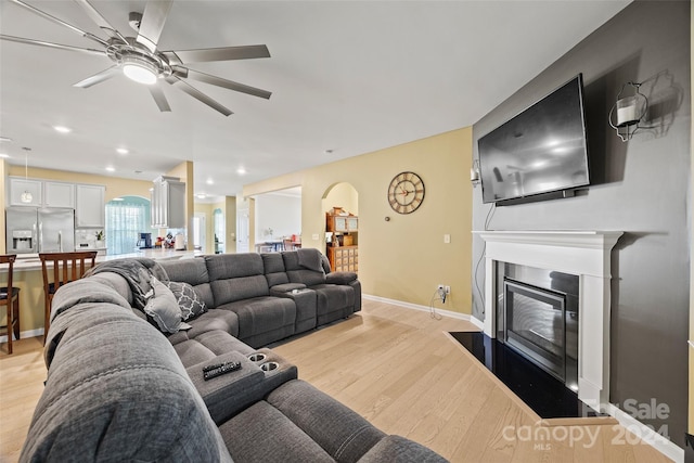 living room with light hardwood / wood-style floors and ceiling fan