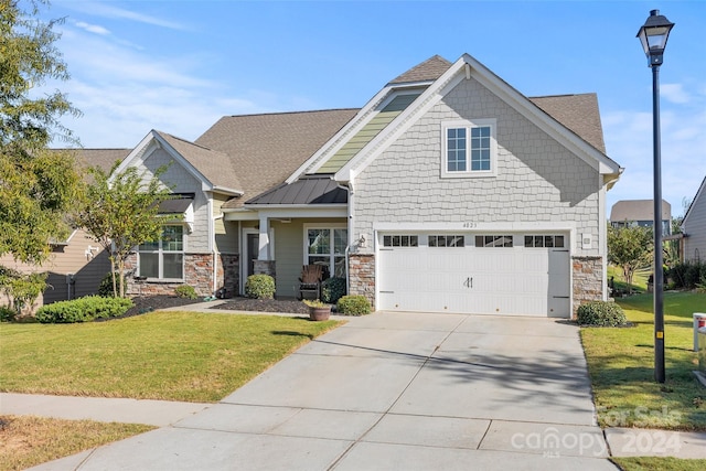 craftsman house with a front yard and a garage