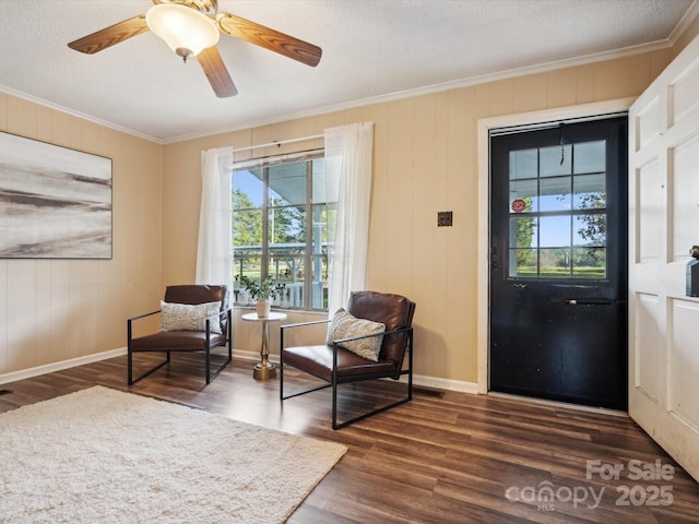 interior space with a textured ceiling, crown molding, ceiling fan, and dark wood-type flooring