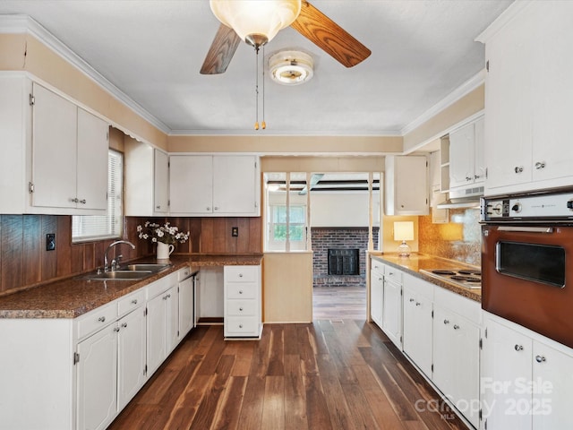 kitchen with white cabinets, black oven, ceiling fan, and sink