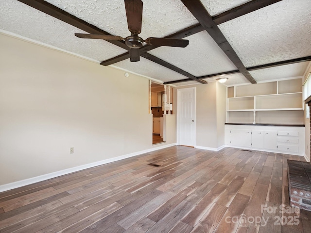 unfurnished living room with hardwood / wood-style floors, coffered ceiling, ceiling fan, a textured ceiling, and beamed ceiling