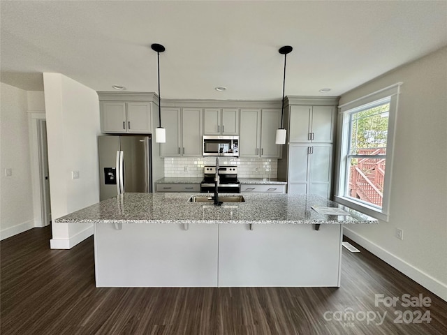 kitchen with sink, gray cabinetry, light stone counters, and stainless steel appliances