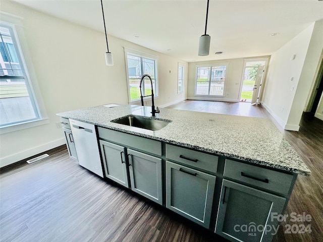 kitchen featuring sink, a kitchen island with sink, decorative light fixtures, and a healthy amount of sunlight