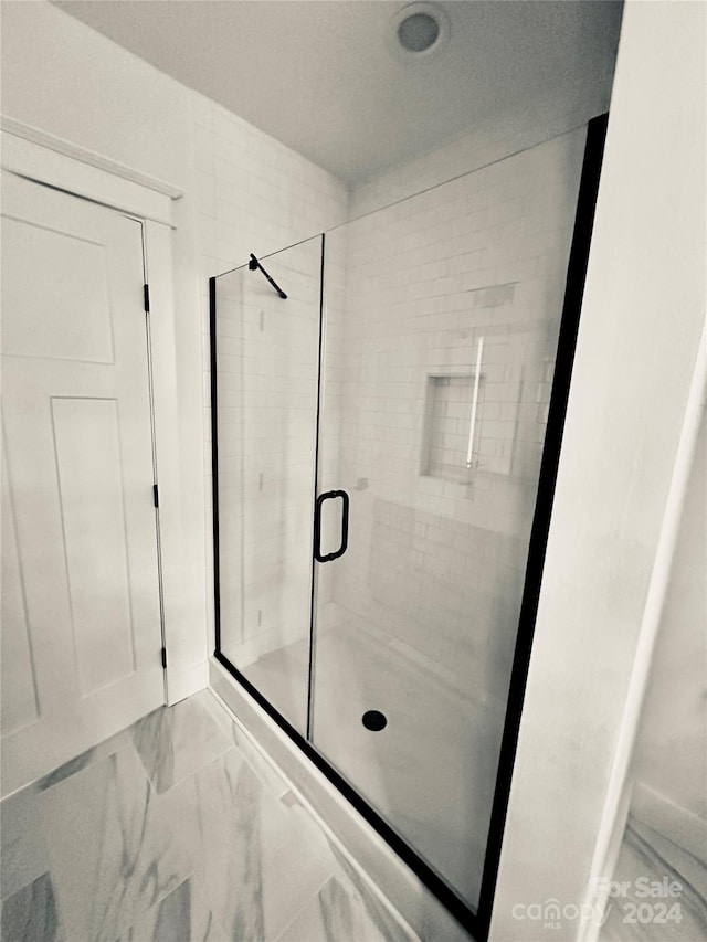 bathroom featuring a shower with shower door