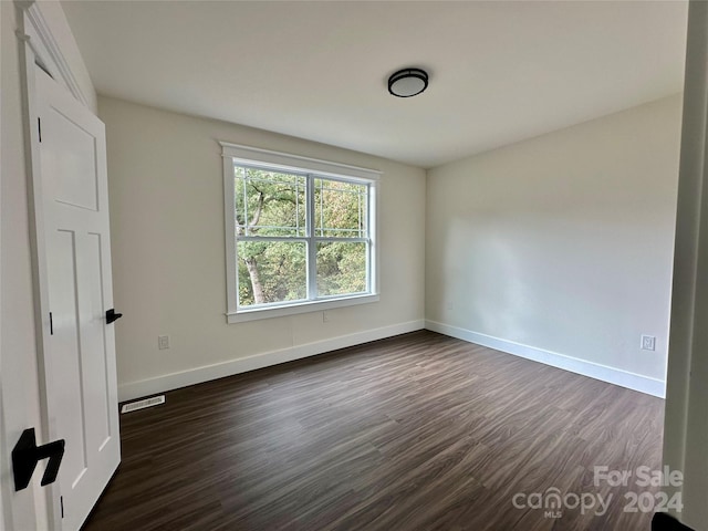 spare room featuring dark hardwood / wood-style floors