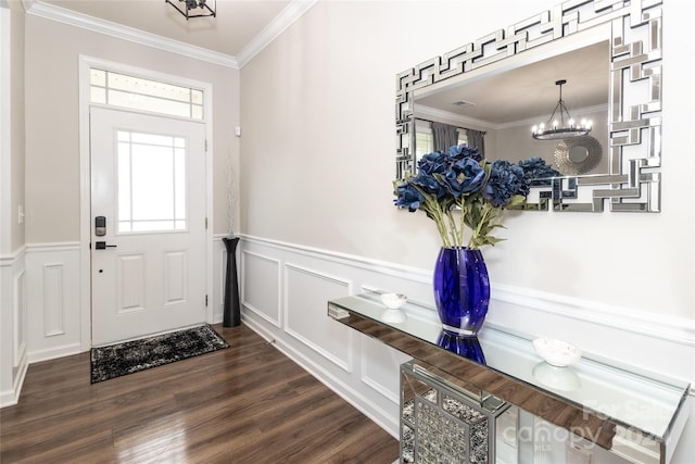 foyer with ornamental molding, dark hardwood / wood-style flooring, and a notable chandelier