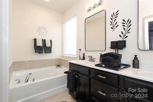 bathroom with a bathtub, vanity, and tile patterned floors