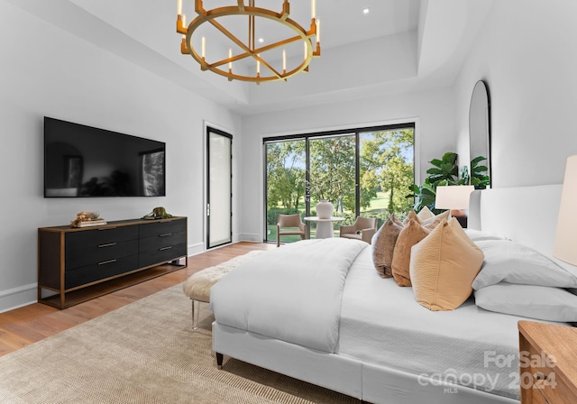 bedroom with light wood-type flooring and a notable chandelier