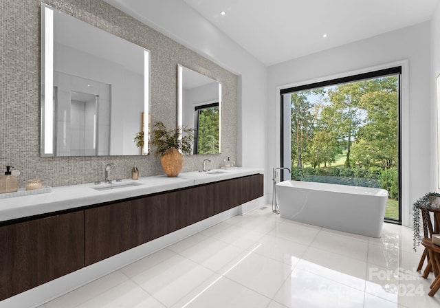 bathroom with vanity, a bathing tub, tile patterned flooring, and decorative backsplash