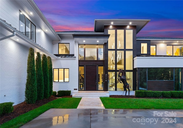 exterior entry at dusk with a yard