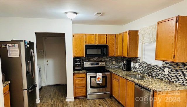 kitchen featuring dark hardwood / wood-style floors, sink, decorative backsplash, appliances with stainless steel finishes, and light stone countertops