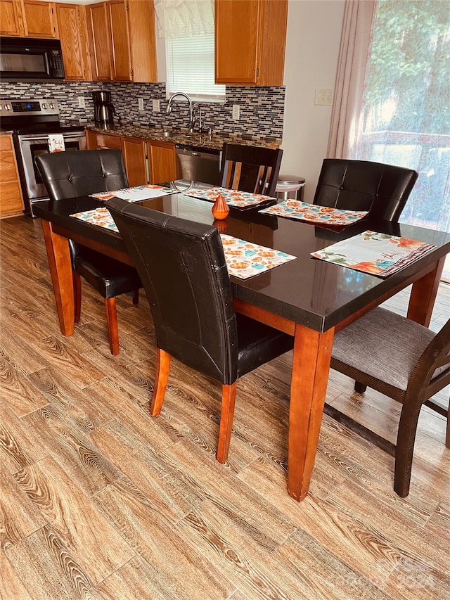 dining space with light wood-type flooring and sink