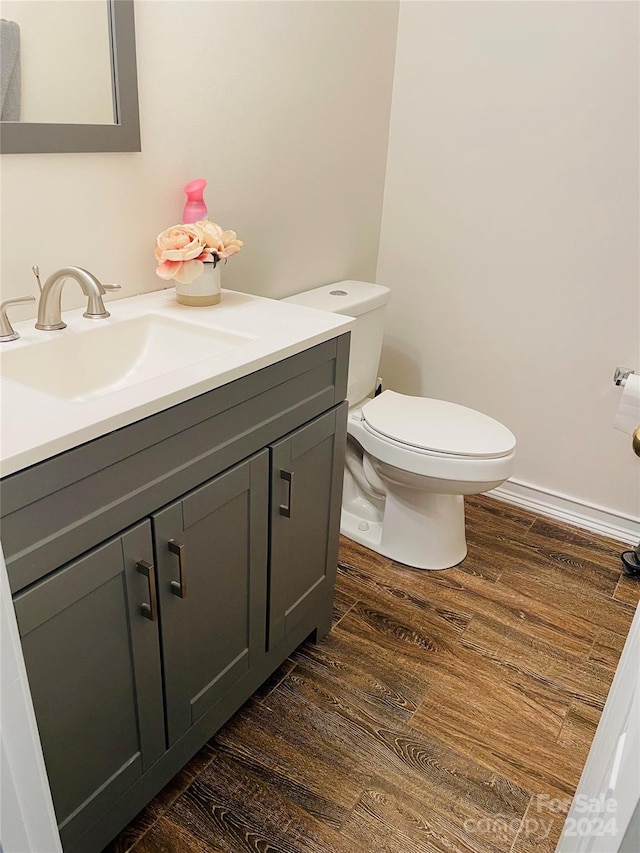 bathroom featuring vanity, hardwood / wood-style floors, and toilet