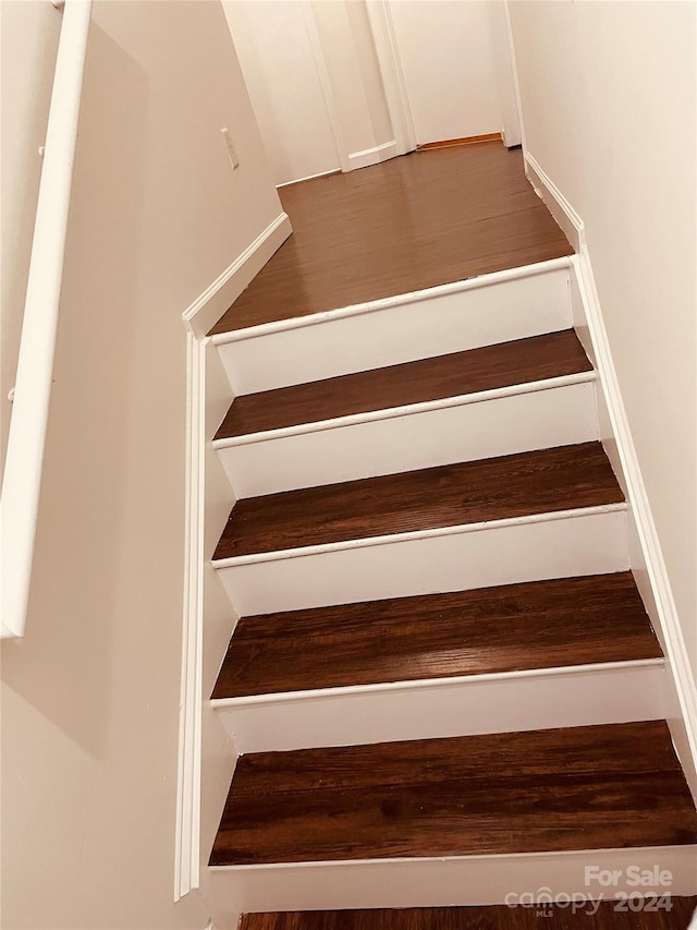 stairway with hardwood / wood-style flooring