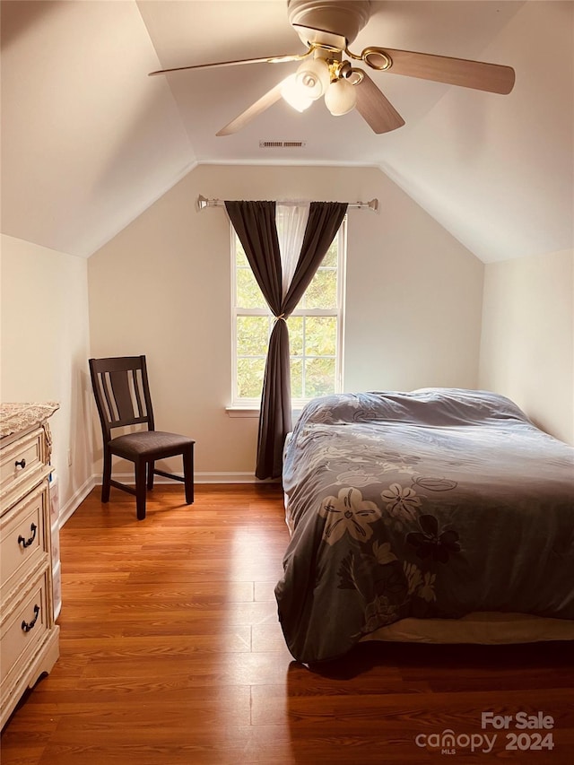 bedroom featuring light hardwood / wood-style flooring, lofted ceiling, and ceiling fan