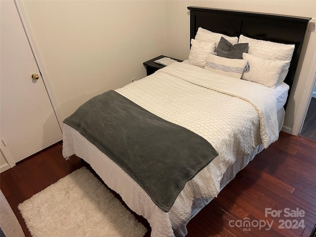 bedroom with dark hardwood / wood-style flooring