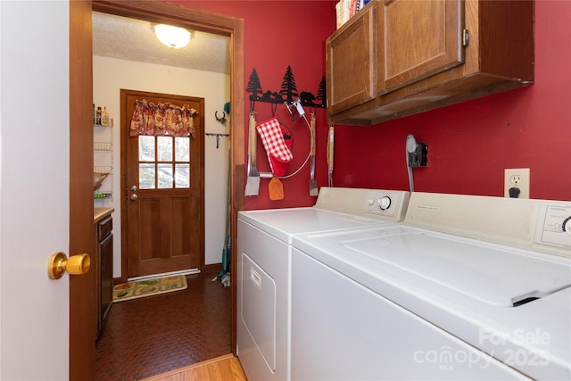 laundry area with cabinet space, washing machine and dryer, and a textured ceiling