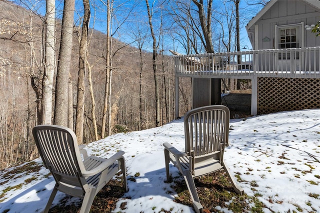 exterior space featuring a view of trees and a wooden deck