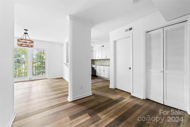 interior space featuring ornamental molding, two closets, french doors, and dark hardwood / wood-style flooring