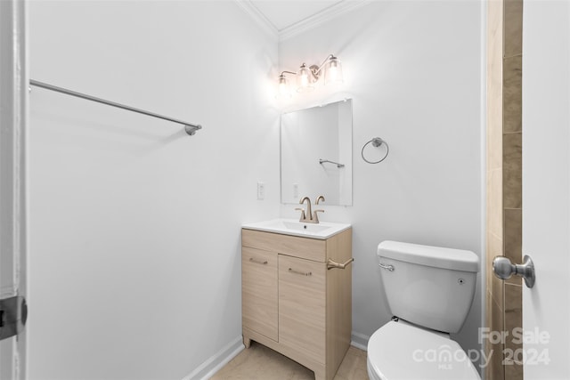 bathroom with ornamental molding, vanity, and toilet