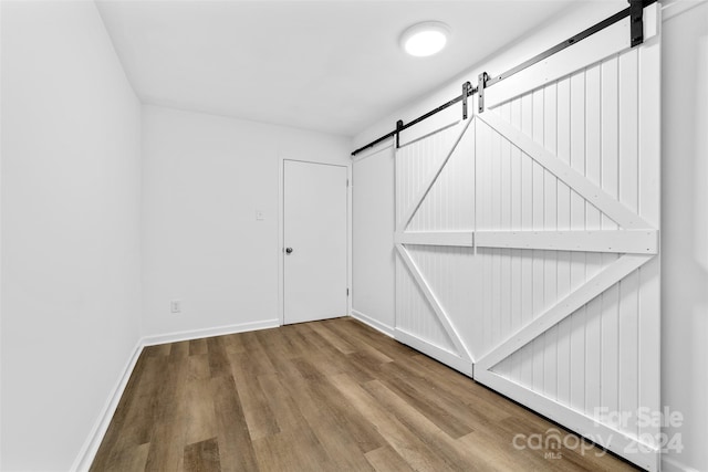 interior space featuring hardwood / wood-style floors and a barn door