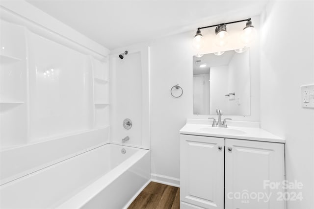 bathroom with wood-type flooring, vanity, and bathtub / shower combination