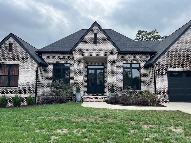 view of front of house featuring a garage and a front lawn