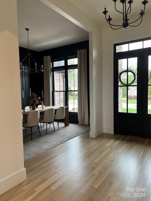 entrance foyer with light hardwood / wood-style floors and an inviting chandelier