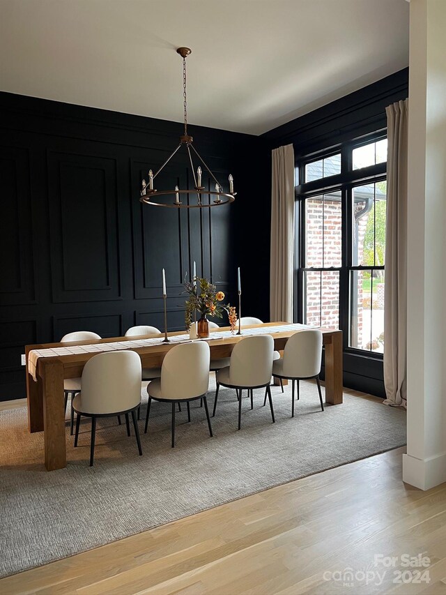 dining room with light hardwood / wood-style flooring and a notable chandelier