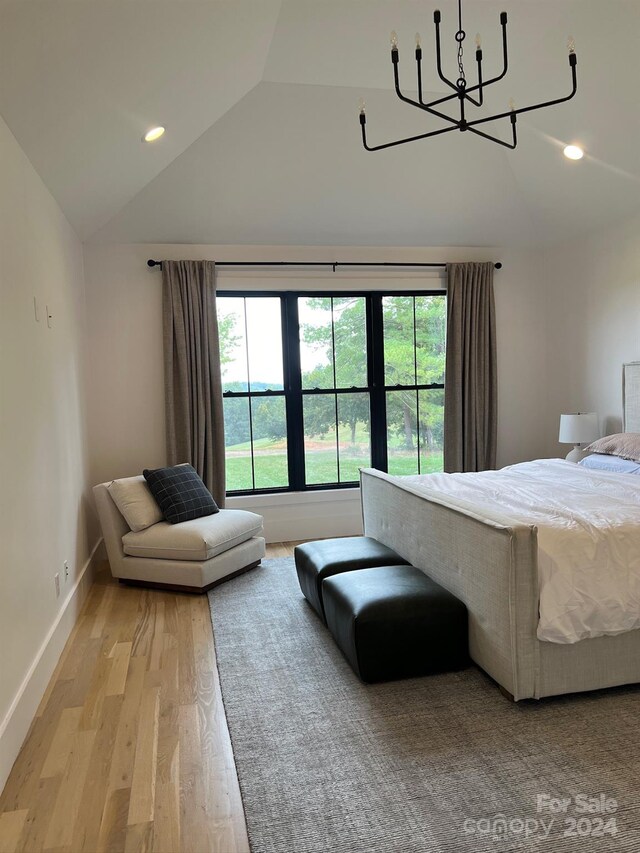 bedroom with light hardwood / wood-style flooring, a chandelier, and lofted ceiling