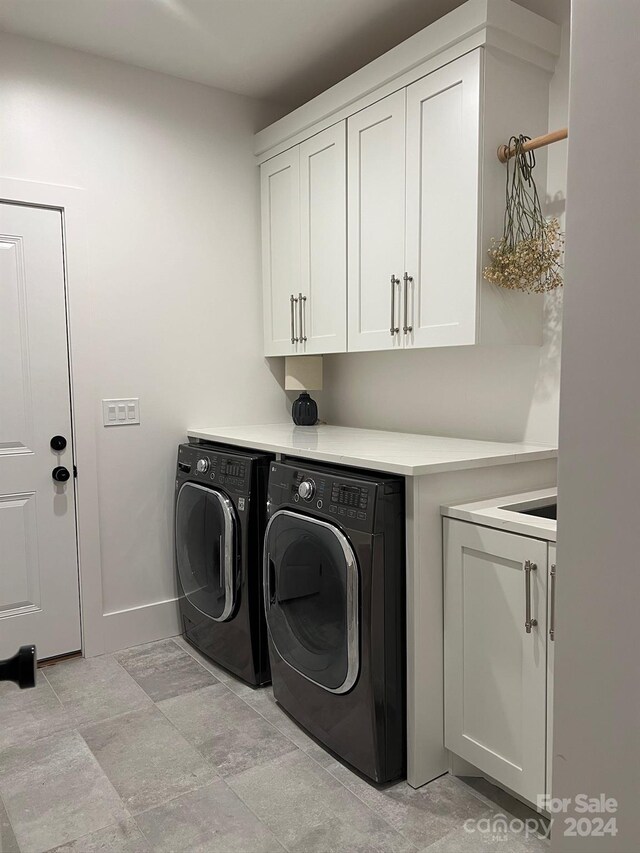 laundry room featuring washing machine and dryer and cabinets