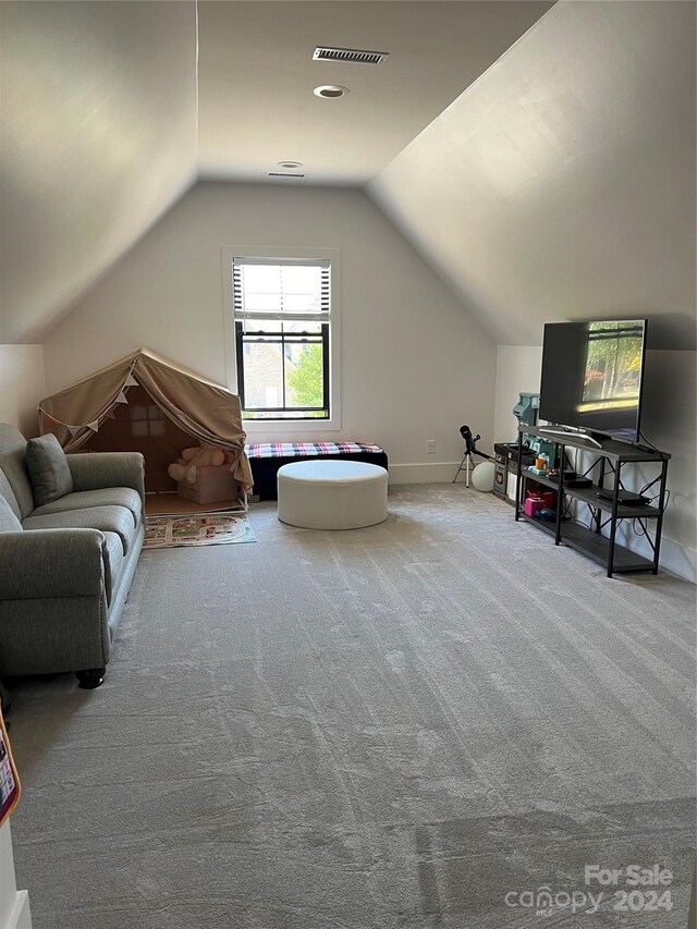 additional living space featuring lofted ceiling and carpet flooring