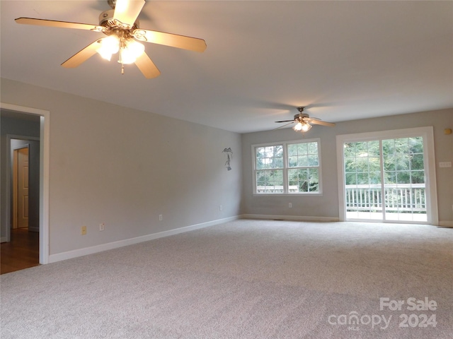 empty room with carpet, a ceiling fan, and baseboards