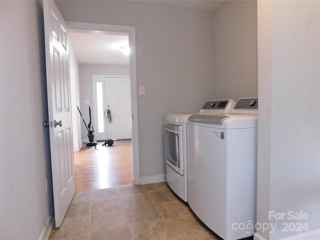 laundry area with light wood-type flooring and washing machine and dryer