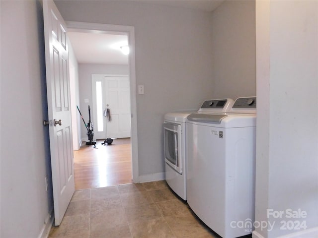 washroom featuring washing machine and dryer, baseboards, and laundry area