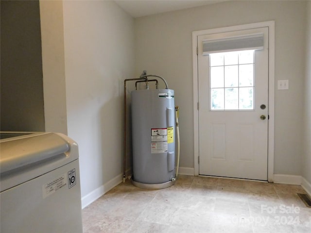 utility room featuring electric water heater and washer / dryer