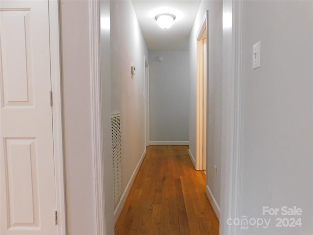 hall featuring baseboards and wood finished floors