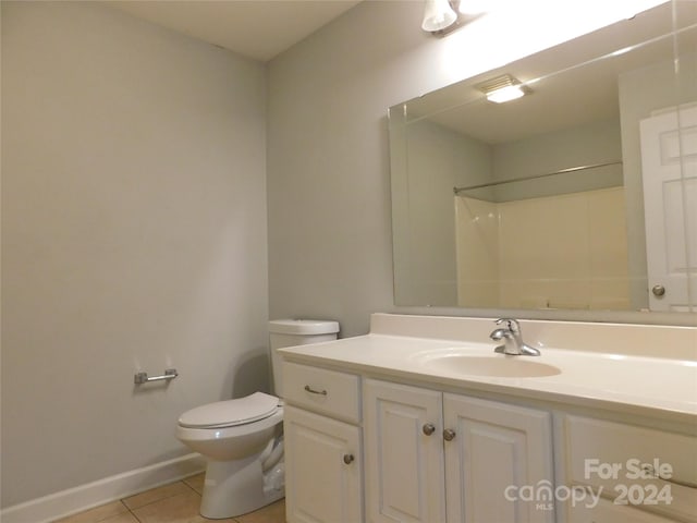 bathroom featuring a shower, tile patterned flooring, vanity, and toilet