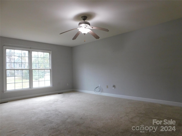 carpeted spare room with baseboards and ceiling fan