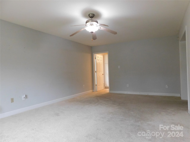 empty room featuring light carpet, baseboards, and ceiling fan