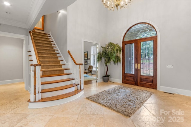 entryway with baseboards, stairs, and crown molding